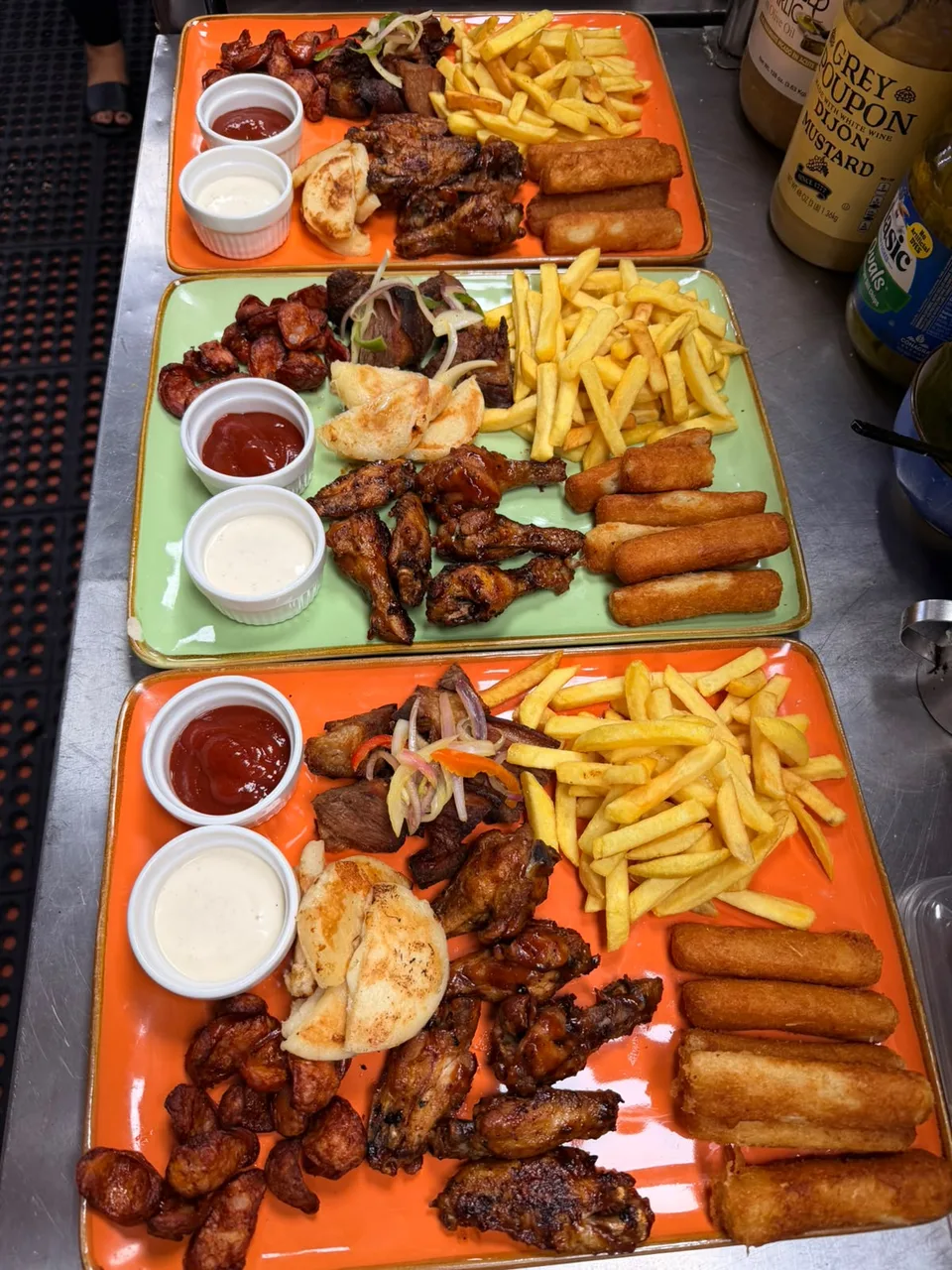 Tablas de la cocina con bocados, papas fritas y salsas